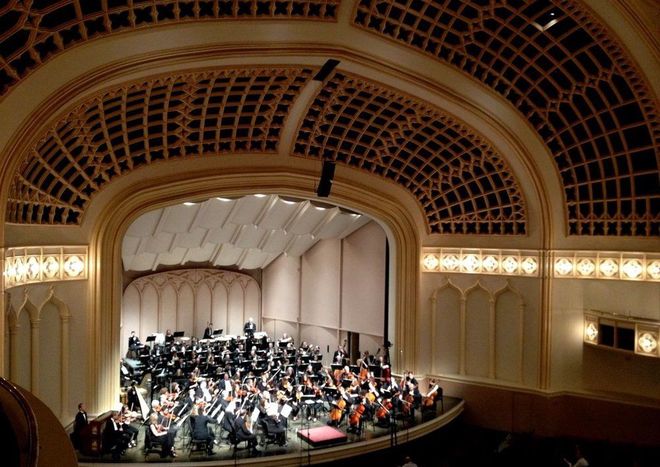 Orchestra performing on stage as viewed from a balcony