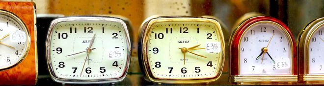 Several old electric clocks in a row